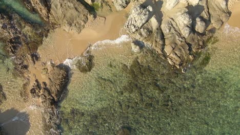 Antenne-Von-Oben-Nach-Unten-Meer-Klare-Wasserwellen-Brechen-Beim-Rollen-In-Fels--Und-Sandstrand