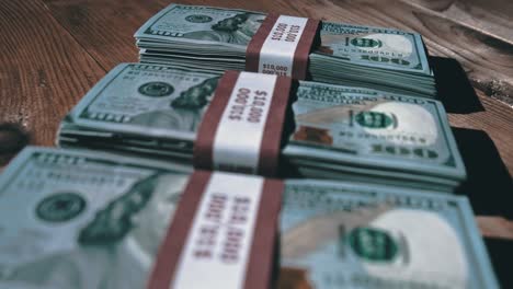 three stacks of 10000 american dollars banknotes in bundles lie on wooden table