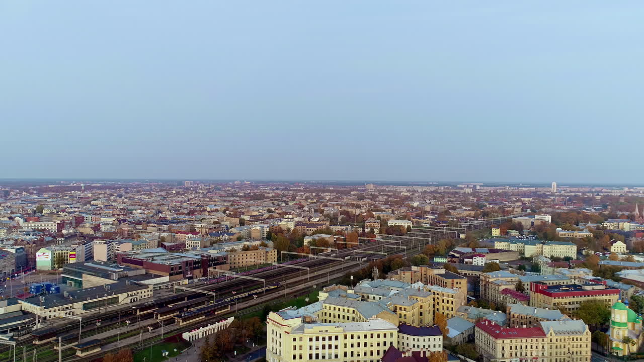 toma de dolley de drones hacia atrás de una gran estación de tren de riga detrás del mercado central
