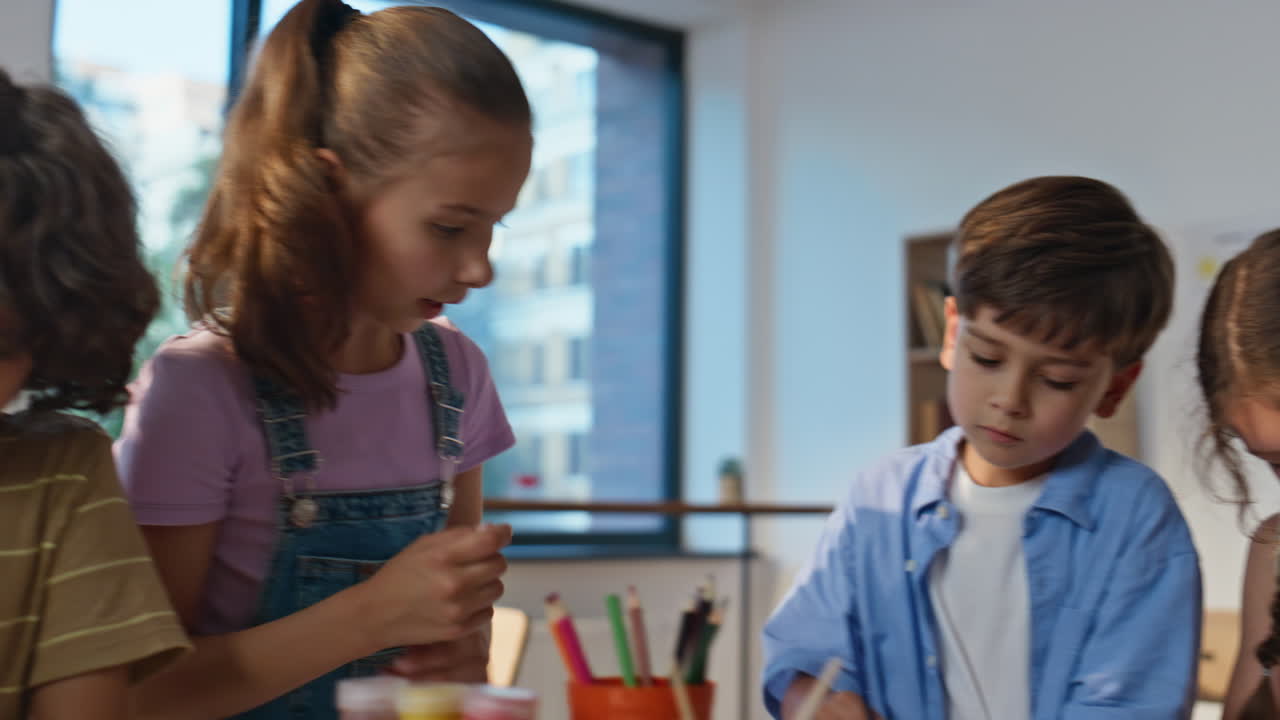Artclass girl drawing pencil sitting table with classmates engaged work closeup