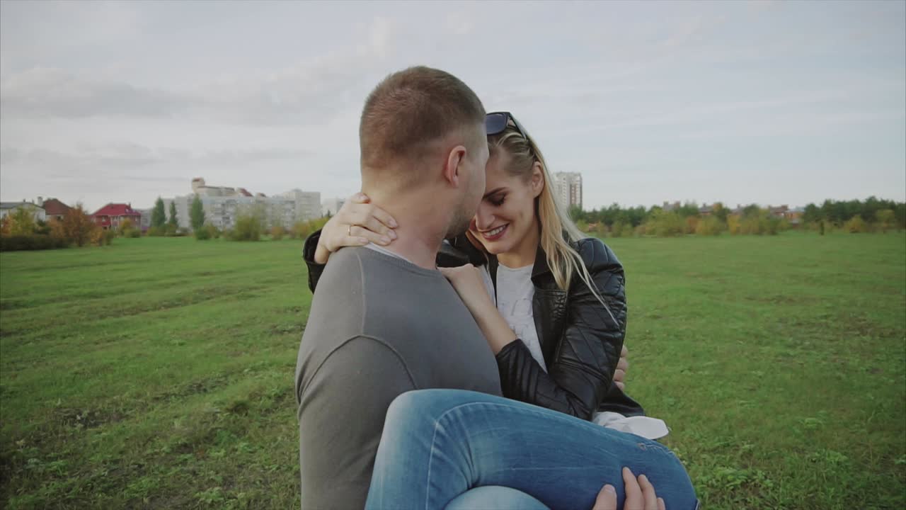 una pareja abrazada en un parque.