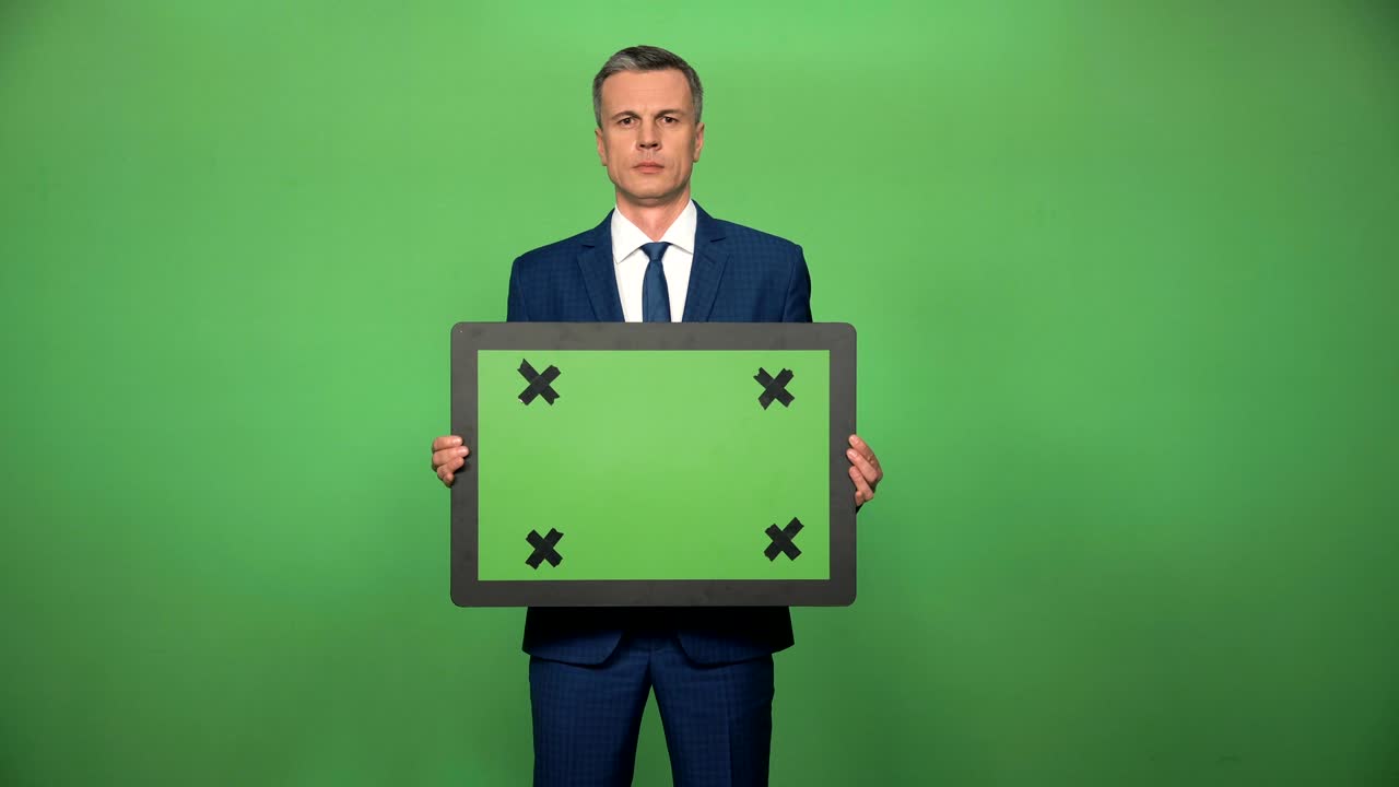 Young male holding chromakey board
