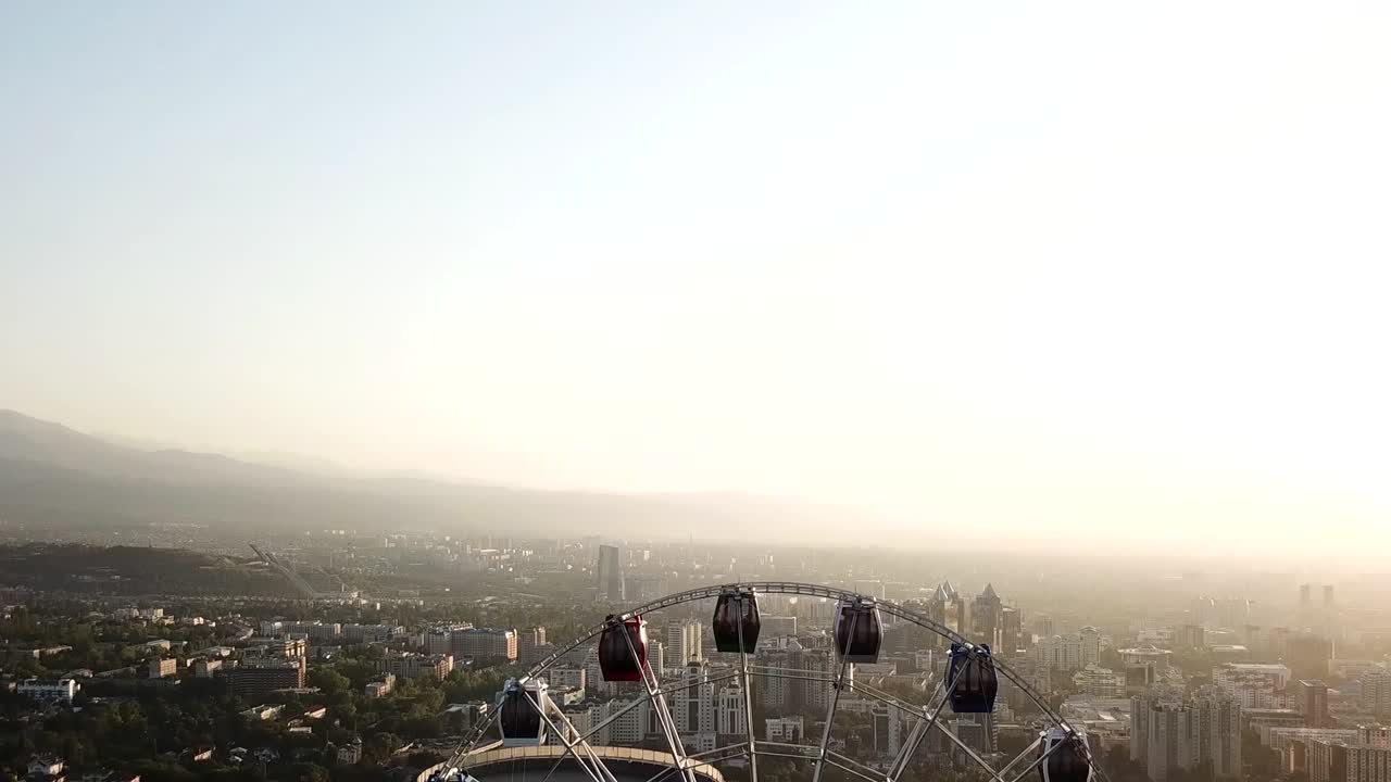 해가 지는 초록 언덕에 있는 페리스  (ferris wheel) kok tobe
