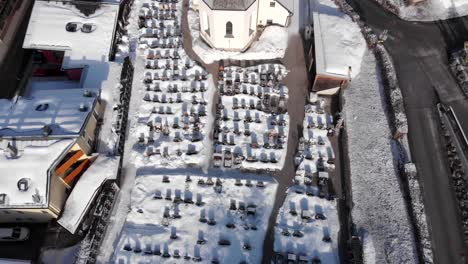 droneview del cementerio y la iglesia en un pequeño pueblo de alpes nevados
