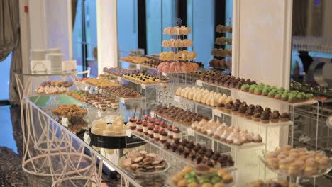 candy bar displaying an array of sweets in various forms, shapes, and vibrant colors, inside of a luxury restaurant reception
