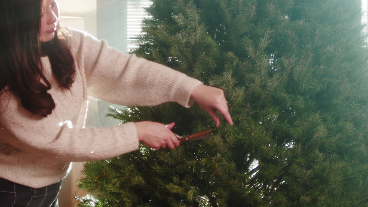 Woman Trimming a Christmas Tree