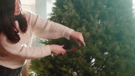 woman trimming a christmas tree