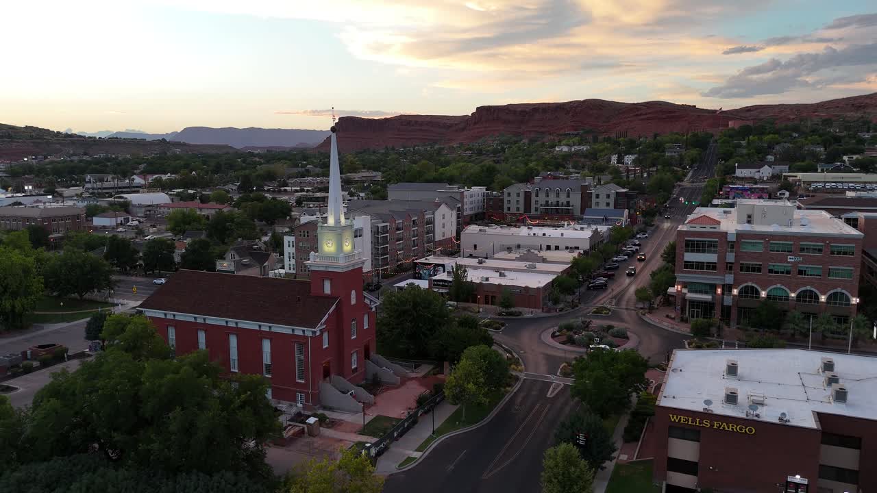Aerial View of a Town with a Prominent Church and Red Rock Mountains at Dusk