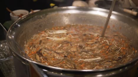 방 ⁇  에 있는 한 여자 는 전통적 인 태국  ⁇ 비 에서 음식 을 조리 하고 있으며, 그 를  ⁇ 고 있다