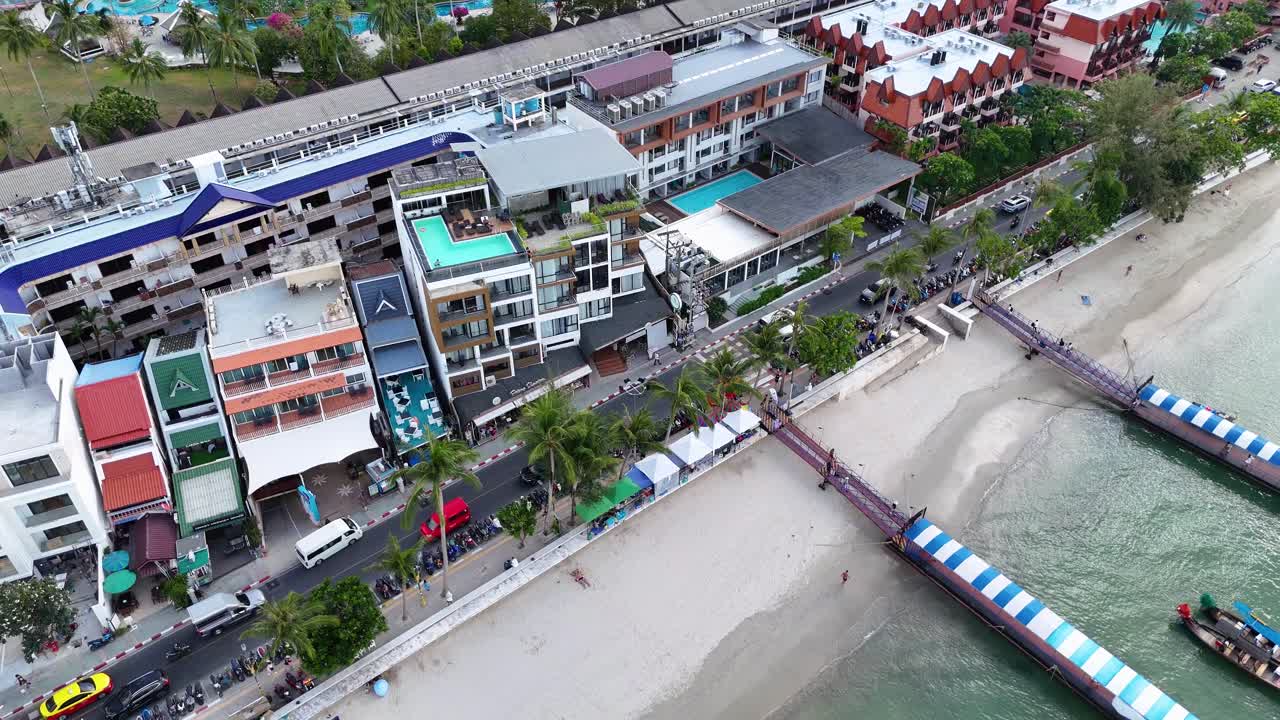 las imágenes aéreas capturan vibrantes edificios frente a la playa y barcos de cola larga en phuket, tailandia, mostrando el movimiento dinámico de la cámara y la iluminación brillante