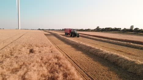 Tractor-driving-on-a-field-assisting-in-the-harvest