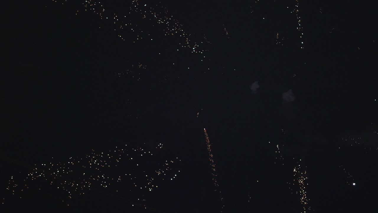 Bright sparks and fireworks soar into the heavens, creating an enchanting spectacle against the backdrop of the night