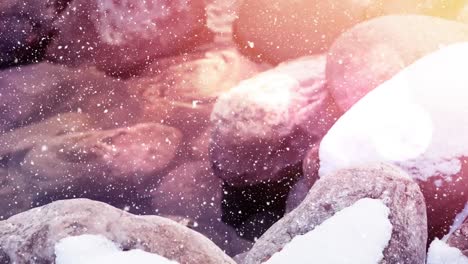 Digital-animation-of-spots-of-light-against-snow-falling-over-rocks-on-winter-landscape