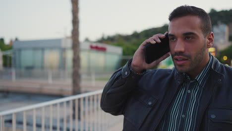 young man calling on smartphone outdoors.