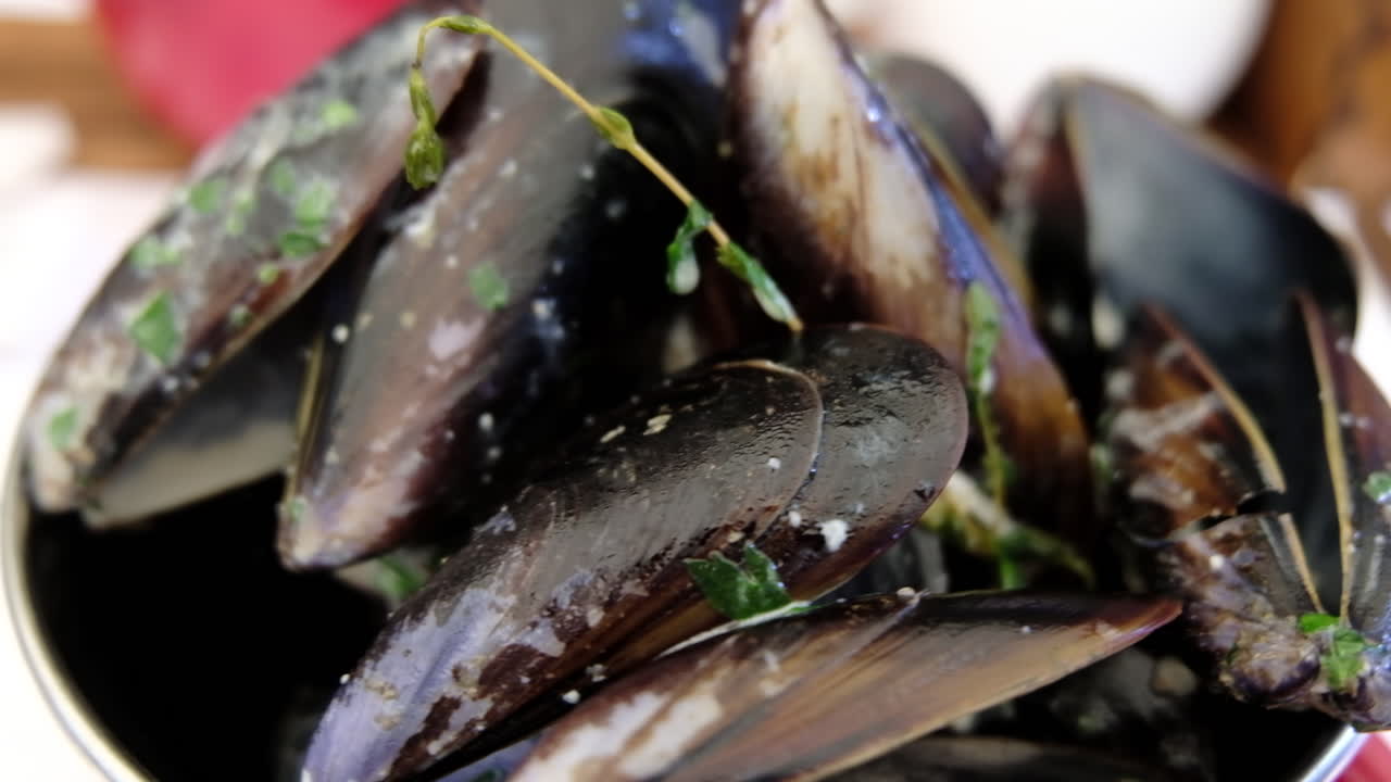 Primer plano de un cuenco de mejillones cocinados con perejil