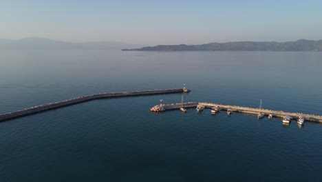 View-from-drone-to-Mediterranean-seascape-in-the-marina-of-Vrahati,-Greece-with-small-fishing-boats-|-4K