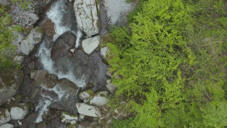 drone view flying down beautiful mountain stream in tottori japan