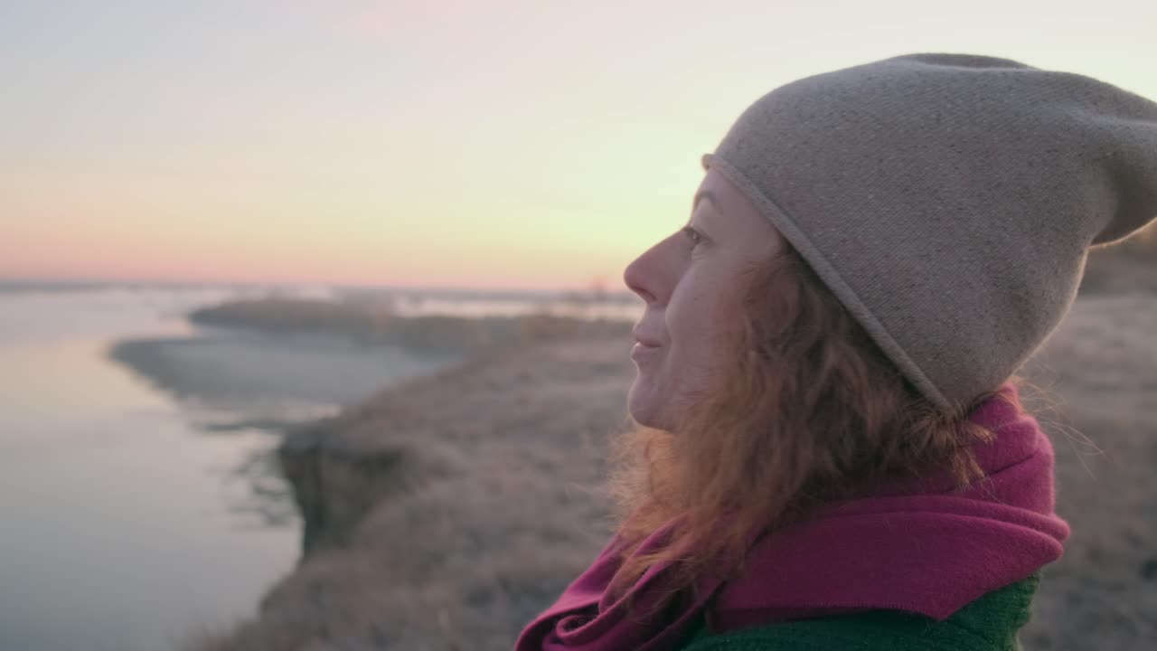 Woman watching sunrise over a river