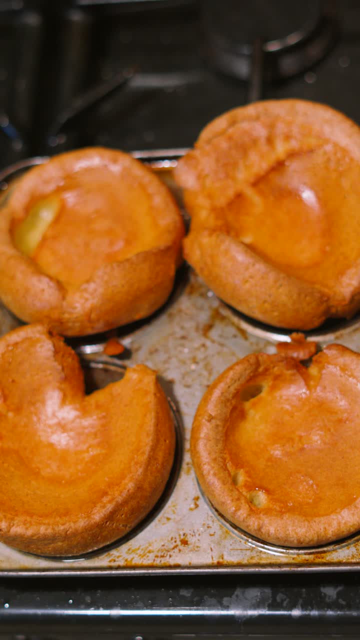 Vertical Video Overhead View of Perfect Golden British Yorkshire Puddings After Cooking in Tray Resting on Kitchen Stove. Tradtional English Cuisine Served with Roast Dinners.