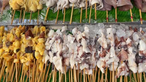 Primer-Plano-De-Brochetas-De-Calamar-Crudo-Exhibición-De-Comida-Callejera-En-Tailandia