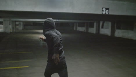 african american male running away in a parking garage