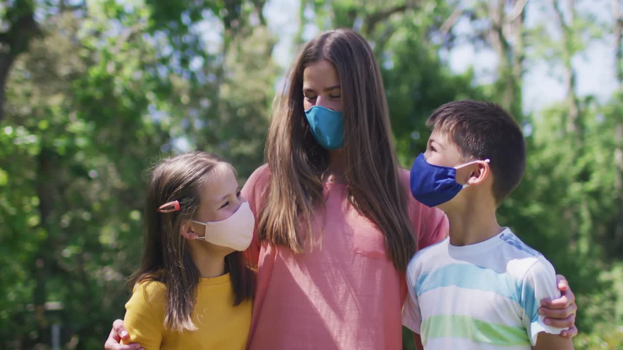 카우카스족 가족 이 얼굴 마스크 를 착용 하고 정원 에서 함께 서 있는 초상화