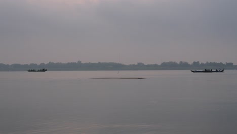 motorized fishing boat going down the river in early morning fog