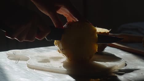 manos cortando piña, de cerca