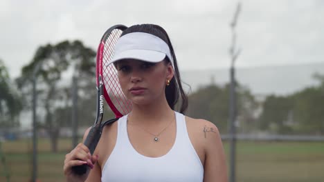 A-tennis-player-walking-in-a-sports-outfit-with-a-racket-in-her-hand-over-the-shoulder