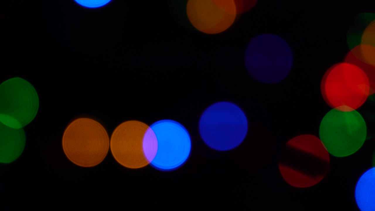 Shimmering abstract colored circles defocused christmas lights background. Blurred fairy lights. Out of focus holiday background christmas tree. Light bokeh from Xmas tree. Xmas and New Year theme. 4k video