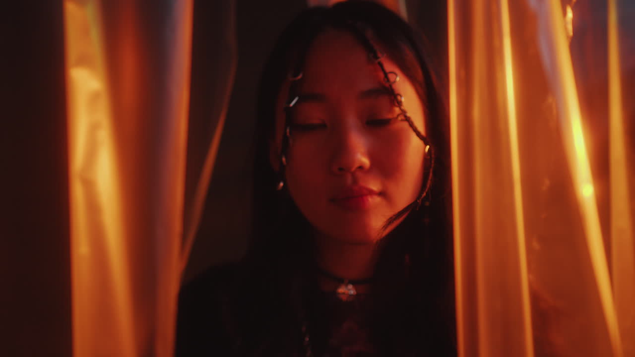 Young Beautiful Asian Woman Posing on Camera in Multicolored Neon Light