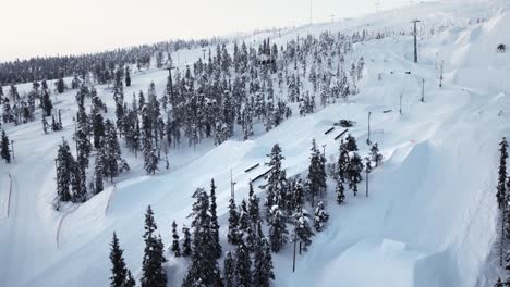 Drone-shot-flying-over-ski-resort-in-Lapland-with-slopes-and-chairlift