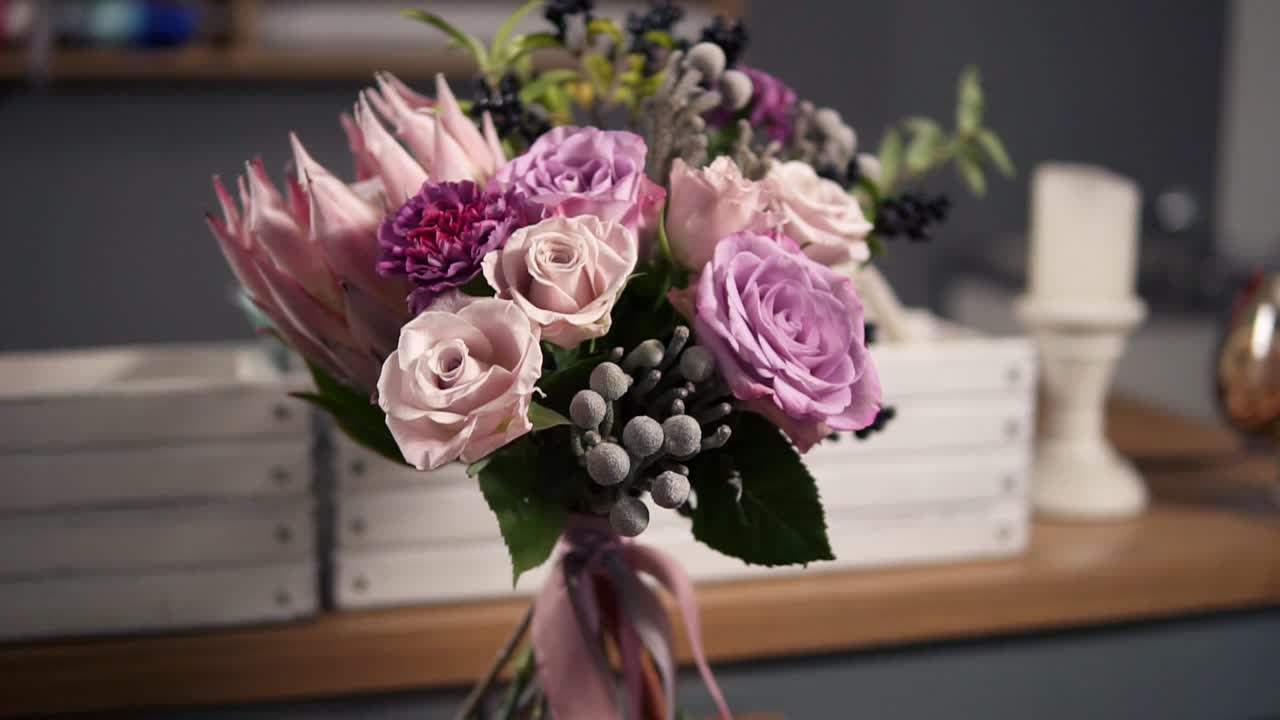 Side view of beautiful fresh bouquet in the flower shot: floral composition consists of Rose, Brunia, Protea with beautiful