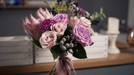 Side-view-of-beautiful-fresh-bouquet-in-the-flower-shot:-floral-composition-consists-of-Rose,-Brunia,-Protea-with-beautiful