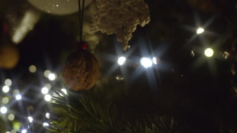 gentle pan to view ornaments and lights on christmas tree, close-up