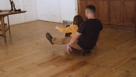 happy father and daughter skateboarding around apartment.