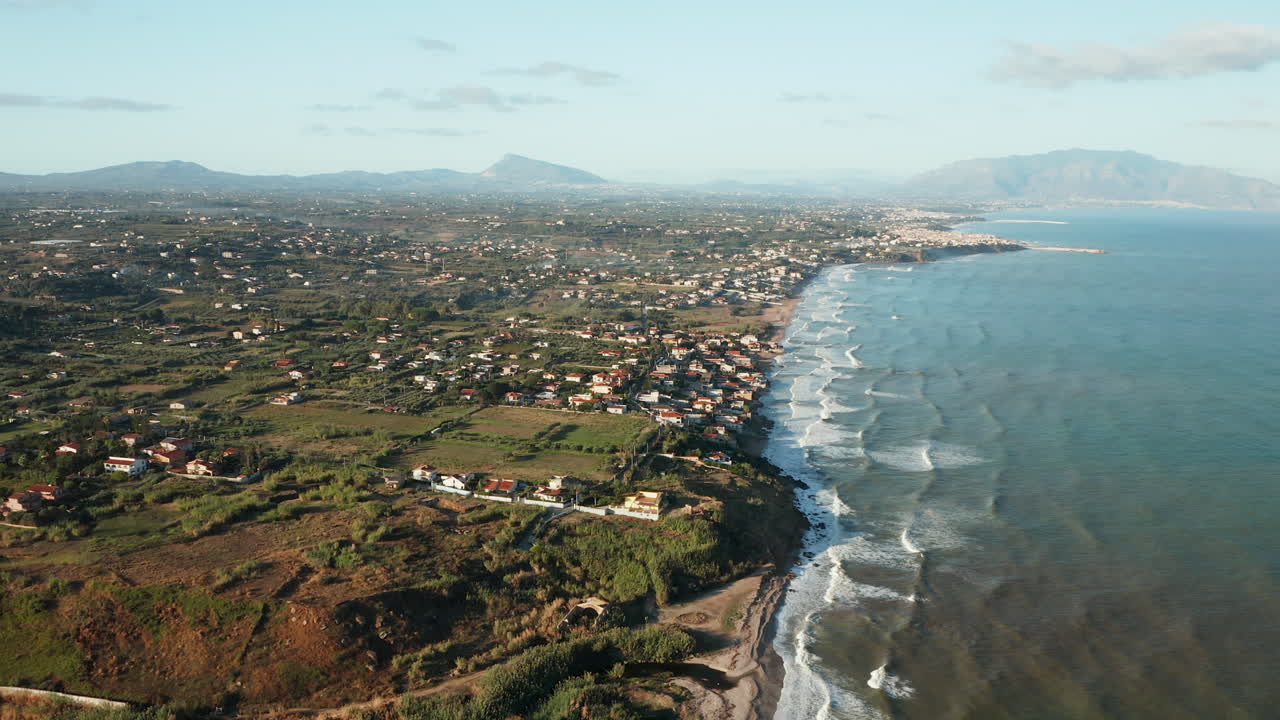 vista aérea de las olas del océano rompiendo en la costa de la ciudad de terrasini en palermo, sicilia, italia