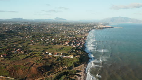 Vista-Aérea-De-Las-Olas-Del-Océano-Rompiendo-En-La-Costa-De-La-Ciudad-De-Terrasini-En-Palermo,-Sicilia,-Italia