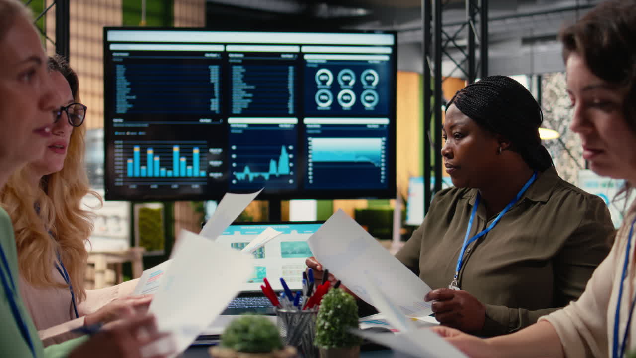Vertical Video Diverse team of businesswomen gather around the table in a corporate office