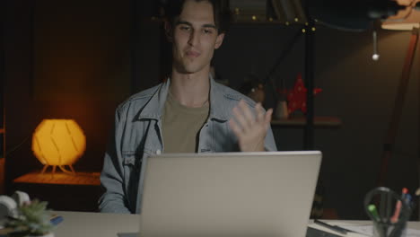 young man working late at night on laptop