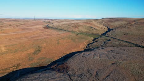 distant car driving down a country road in the moors of the uk with barron landscape