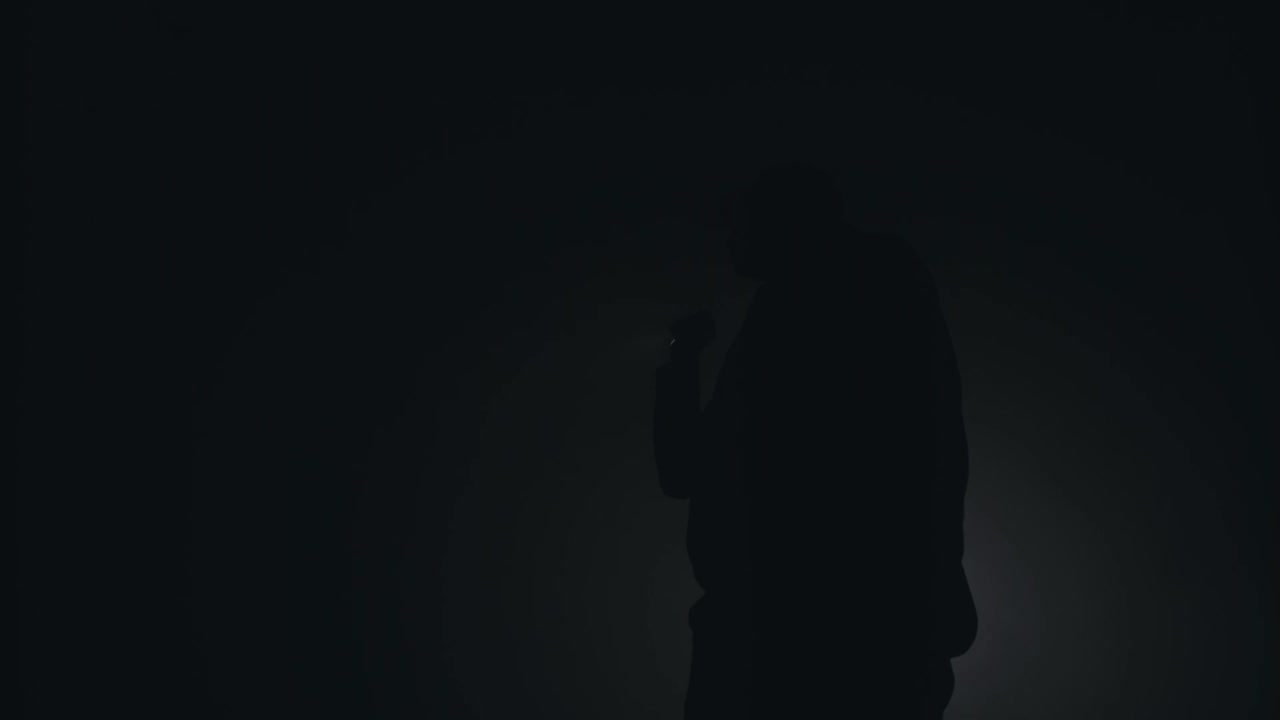 silueta de un hombre fumando en una habitación oscura