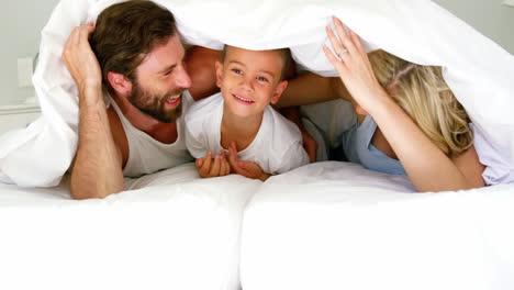 familia feliz jugando juntos en una cama