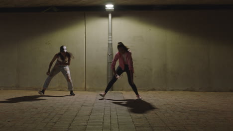 Mujer-Bailando-Joven-Bailarina-De-Hip-Hop-Chicas-Bajo-La-Luz-De-La-Calle-Practicando-Movimientos-De-Danza-Libre-Contemporánea-Practicando-En-La-Ciudad-Por-La-Noche