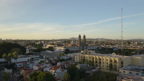 drone flies low over trees to our lady of zapopan in guadalajara, mexico