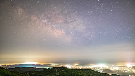 milky way time lapse with light coming from the limassol village in cyprus