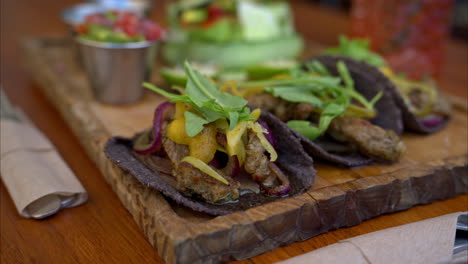 Slow-motion-panning-of-Mexican-beef-tacos-made-in-Yucatan-using-traditional-spices-called-recaudo-on-blue-corn-tortillas-and-red-onion