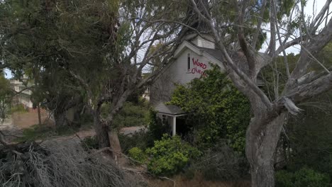 Slow-Motion-Aerial-of-Abandoned-Overgrown-Church-hidden-my-trees-Monterrey-Fort-Ord-California