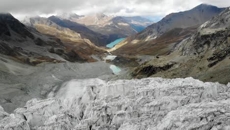 aerial view over the edge of the moiry glacier near grimentz in valais, switzerland with of the glacial tongue and lake in the valley in the background of the crevasses