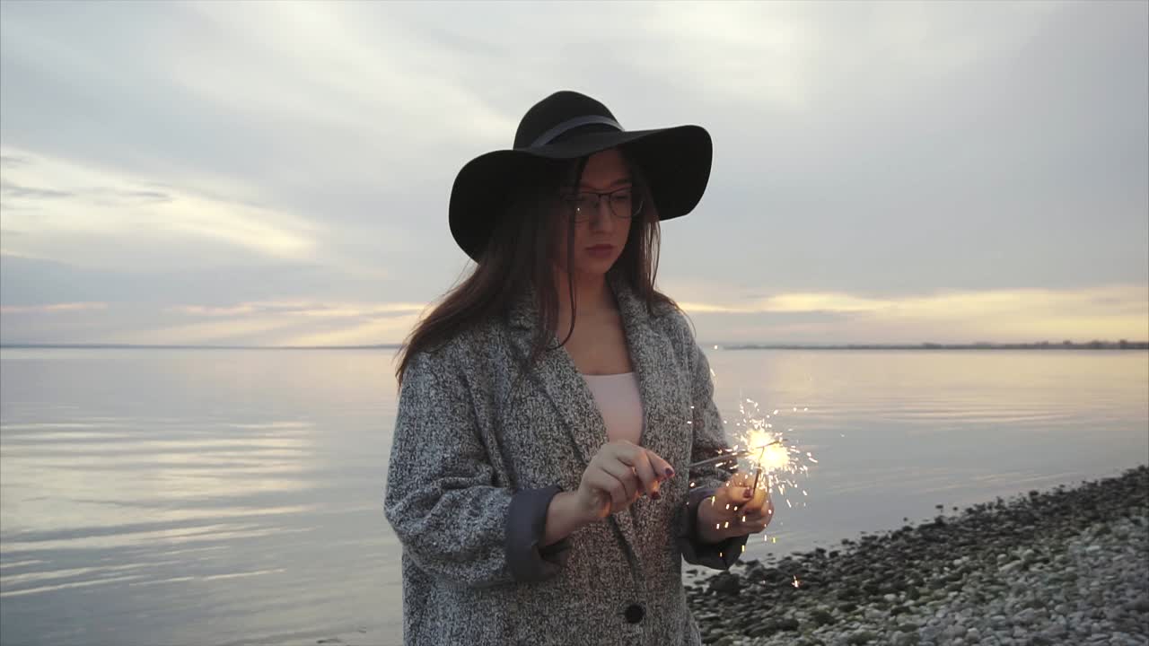 женщина с искрой на закате на пляже